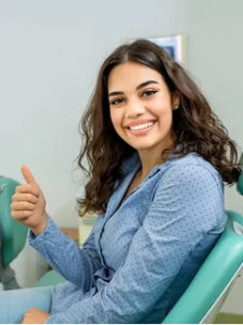 Satisfied patient smiling big with thumbs up.